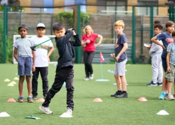 Young golfers practicing their skills while receiving guidance from a coach.