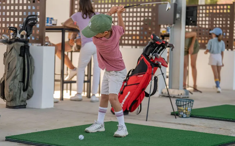 a boy swinging a golf club