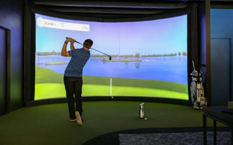 a man playing golf in a room