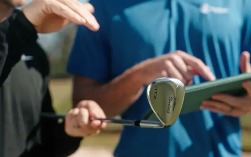 Golfers reviewing the new Cleveland RTZ wedge, designed for rust-free performance with Z-Alloy.
