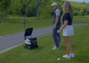 a man and woman standing on a golf course