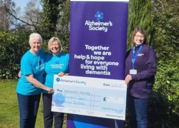 a group of women standing next to a large sign
