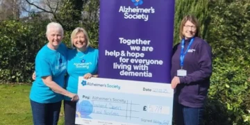 a group of women standing next to a large sign