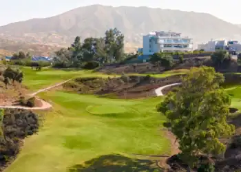 a golf course with a building in the background