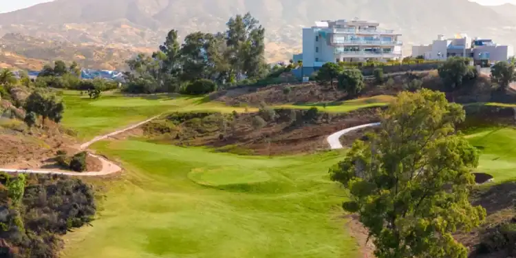 a golf course with a building in the background
