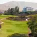 a golf course with a building in the background
