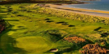 a golf course with sand bunkers and a beach