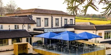 a building with a patio and umbrellas