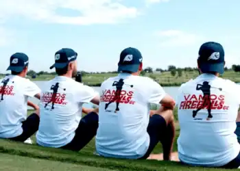 a group of men sitting on grass
