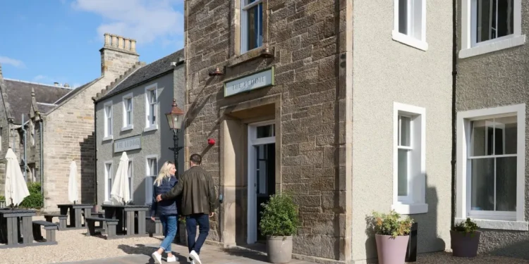 a man and woman walking in front of a building