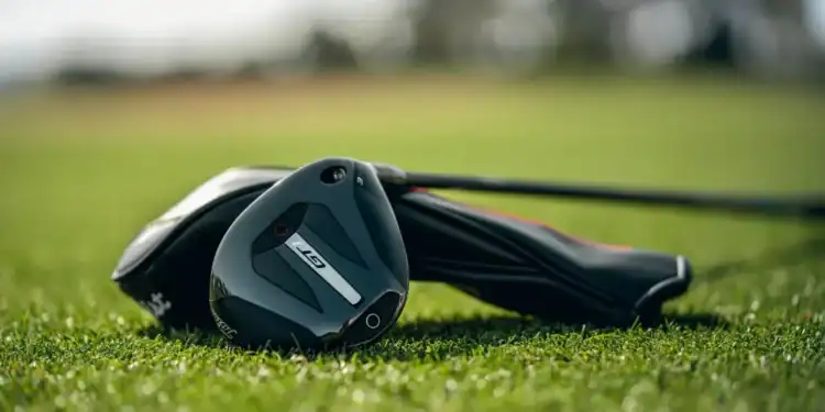 Titleist GT1 3TOUR fairway wood resting on fairway grass with headcover in background.