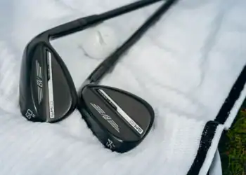 Close-up of Titleist Vokey SM10 Black Vapor wedges with black finish, resting on a white golf towel.