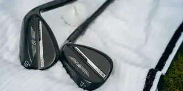 Close-up of Titleist Vokey SM10 Black Vapor wedges with black finish, resting on a white golf towel.