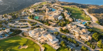a aerial view of a town with a pool and a body of water