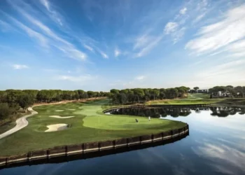 a golf course with water and trees
