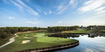 a golf course with water and trees