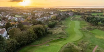 a golf course with a city and houses