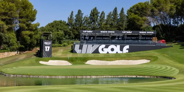 a golf course with a pond and a large black sign