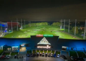 a building with a golf course and cars parked in front of it