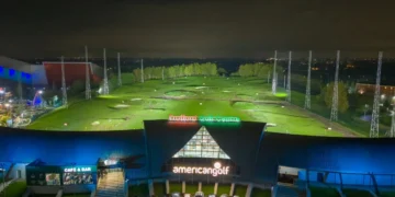 a building with a golf course and cars parked in front of it
