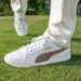 PUMA GOLF Unveils x ARNOLD PALMER Collection for 2025 a person's feet in white shoes on grass