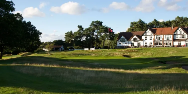 a golf course with a building and a flag on the side