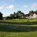 Cheshire Senior Ladies Championship 2025 a golf course with a building and a flag on the side
