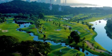 Lush golf course with city skyline backdrop