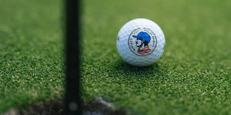 Golf ball near hole on green.