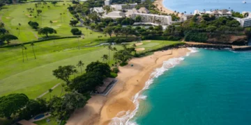 Lush golf course beside stunning coastline.