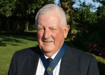 Man in suit at golf club event.