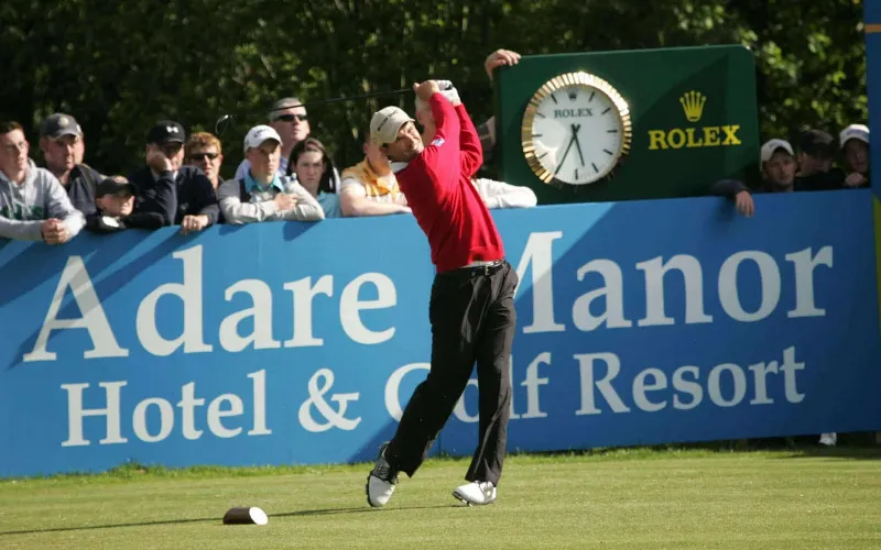 Golfer swinging at Adare Manor event.