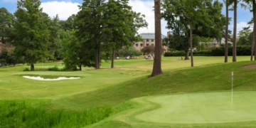 Lush green golf course under blue sky.