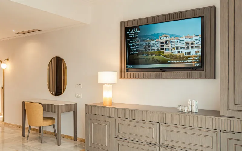 Newly renovated guest room at La Cala Resort featuring modern wood cabinetry and wall-mounted TV.