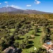 Panoramic view of Picciolo Etna Golf Resort featuring the championship course with Mount Etna in the background.